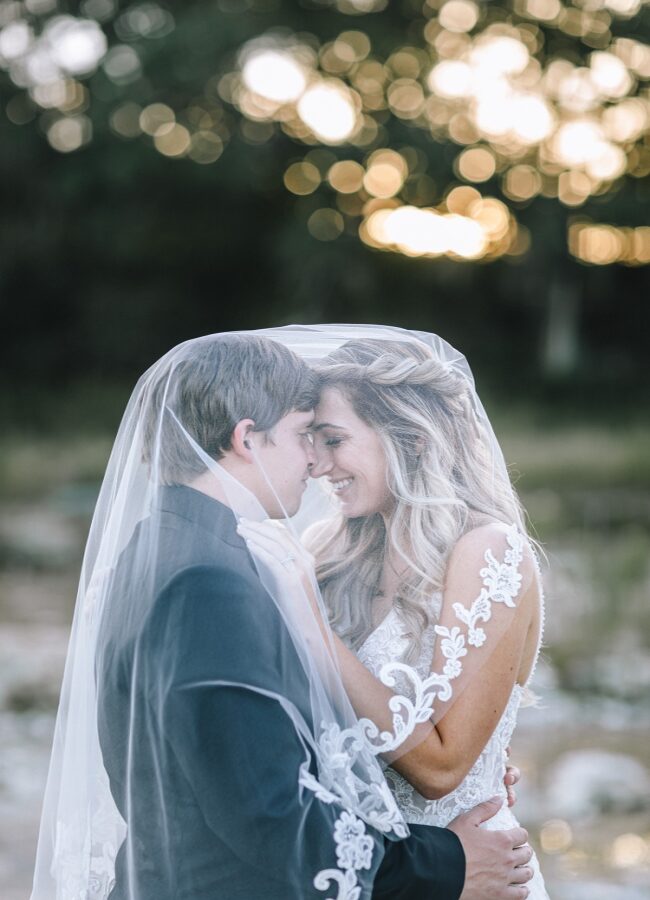 Bride and groom embracing under veil